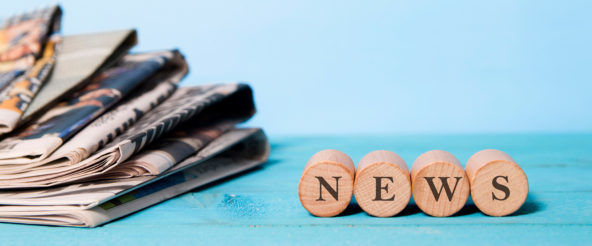 news word on wooden cube and newspapers